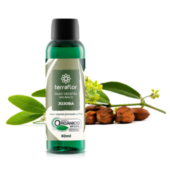 Frasco do óleo vegetal de jojoba orgânico com partes da planta ao fundo.