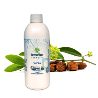 Frasco do óleo vegetal de jojoba orgânico 500ml com partes da planta ao fundo.