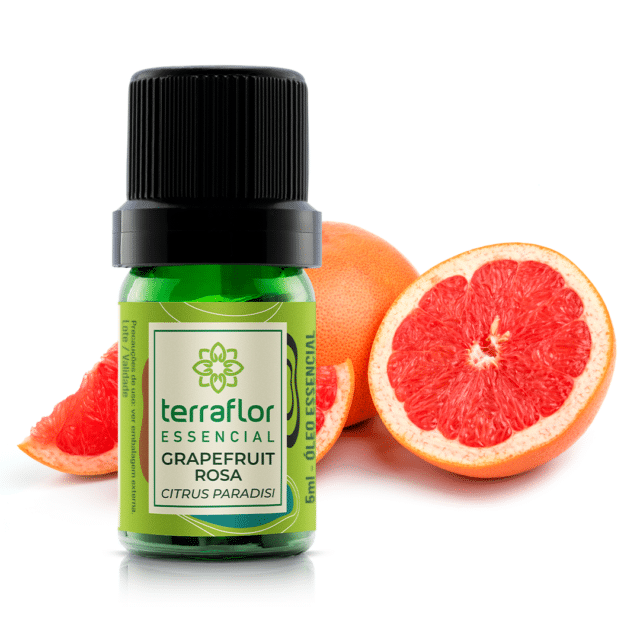 Frasco do óleo essencial de grapefruit rosa com fruta partida ao fundo.